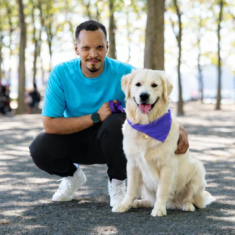 Will and a golden retriever together on a shaded park path