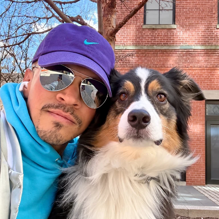 Will and an Australian Shepherd together outside a brick building